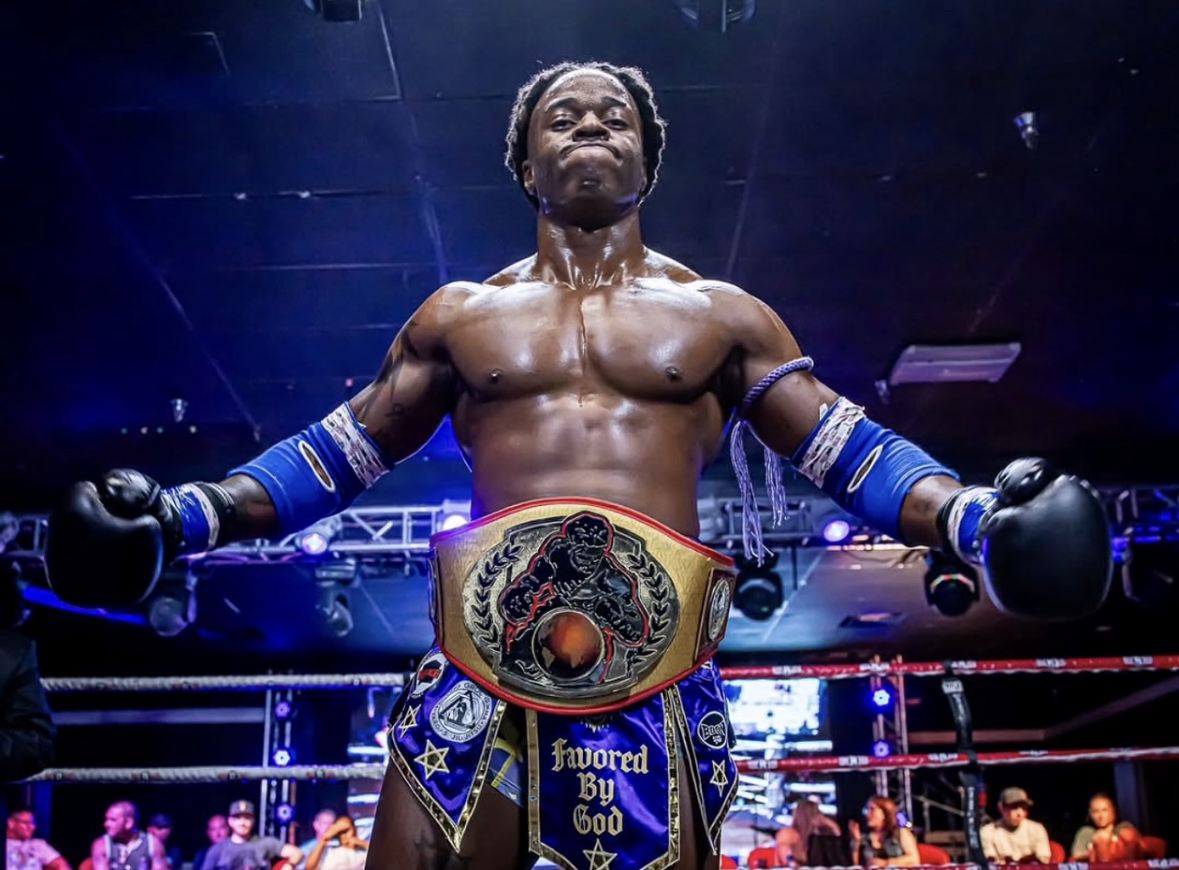Stacey in the ring wearing a championship belt